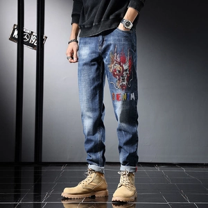 Jean homme coupe ajustée style urbain avec broderie dragon colorée et lettrage denim