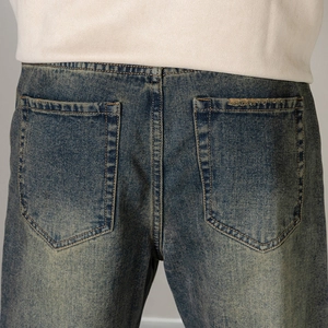 Detailaufnahme der Vintage-Waschung dieser Jeans mit abgenutzten Gesäßtaschen und Bund