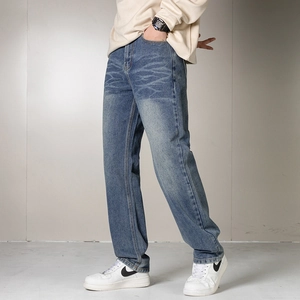 Détail d'un jean bleu foncé pour hommes avec délavage vintage et moustaches de chat