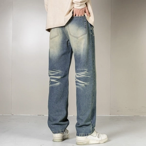 Detailed back view of vintage wash denim jeans with faded whiskering and relaxed fit