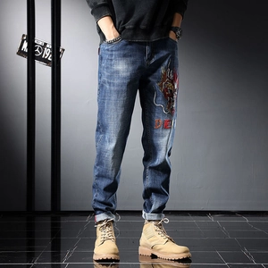 Gros plan d'une broderie de dragon colorée et texte denim sur un jean bleu de style urbain