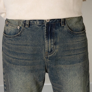Nahaufnahme der Vintage-Jeans-Taille mit Metallknopf und gelben Kontrastnähten aus Denim
