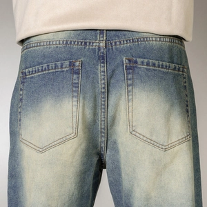 Detail of vintage washed blue denim jeans showing rear pockets and yellow contrast stitching