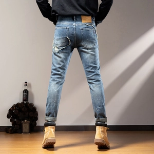 Slim fit men's blue distressed jeans with white splatter and retro washed finish