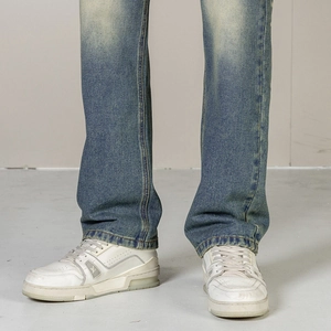 Close-up of vintage washed blue denim jeans featuring a worn-out vibe and straight-leg cut