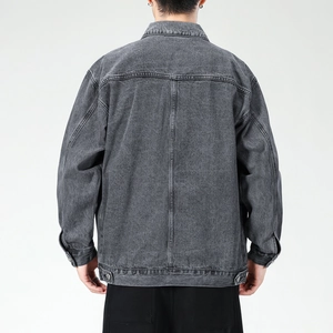 Detail view of the back of a washed grey denim jacket with drop shoulder seams