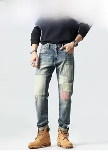 Detail view of retro patchwork denim jeans with vintage washed texture and stitching