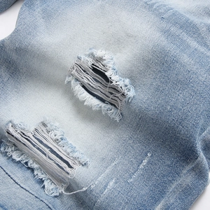 Men's light blue distressed denim shorts with vintage ripped details and fringe finish