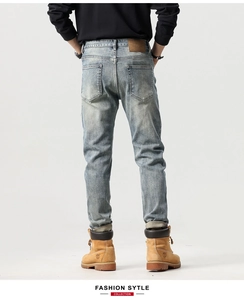 Dettaglio del retro vita con etichetta in pelle ed effetto lavaggio sui jeans da uomo