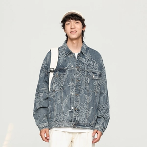 Detail showing high-quality white floral embroidery on a blue denim jacket with metal buttons