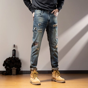 Men's slim fit distressed blue jeans with vintage patchwork and ripped details