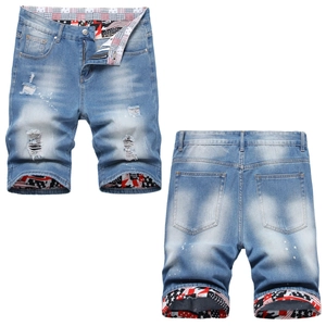 Men's light blue distressed denim shorts with paint splatter and American flag lining
