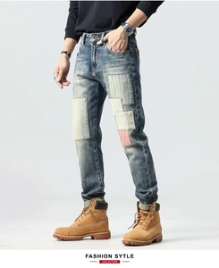 Detail view of mens vintage patchwork denim jeans with contrast stitching and red accent