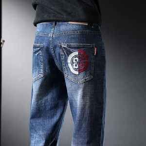 Détail de la broderie rouge et blanche sur la poche arrière du jean bleu stretch