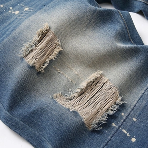 Slim fit denim shorts for men with distressed ripped details and white paint splatters