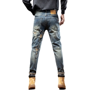 Men's straight-leg denim jeans with star and cross patches and distressed details