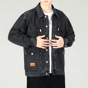 Detail view of washed grey denim jacket featuring orange label and silver metal buttons