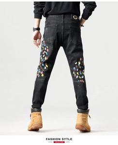 Detailweergave van kleurrijke verfspatten op de achterkant van de zwarte streetwear jeans