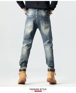 Detailed back view of men's slim fit jeans featuring heavy washed denim and leather patch