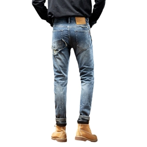 Men's light blue distressed slim fit jeans with paint splatters and ripped details