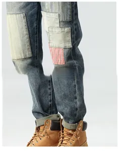 Detail of vintage patchwork denim jeans with red stripe cloth patches and distressed texture
