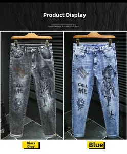 Detail of street style men's jeans featuring dragon embroidery and distressed prints