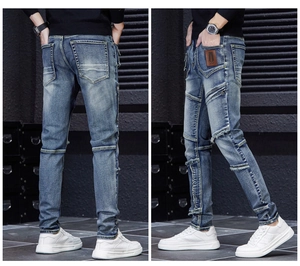 Detailed close-up of blue distressed jeans featuring patchwork stitching and metal zipper