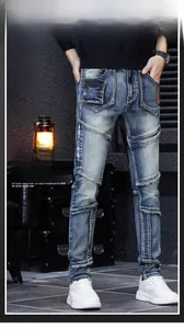 Close-up of men's slim fit blue distressed jeans with patchwork and ripped knee details