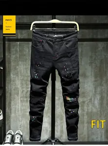 Close-up of slim fit black denim with colorful paint splatters and rainbow patches