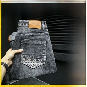 Detail of dark gray jeans featuring ethnic geometric embroidery on the back pocket
