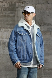 Detail of blue denim jacket showing thick white faux shearling collar and button pockets