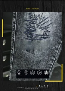 Detail of tree embroidery and cotton fabric texture on dark washed slim fit denim jeans