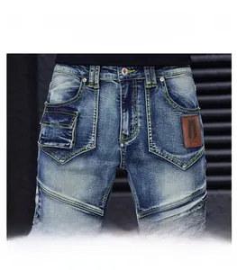 Close-up of blue denim waist with contrast stitching, flap pocket and leather patch label