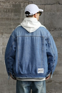 Detail view of denim jacket back with white logo patch and cozy faux fur collar lining