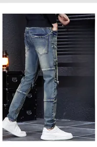 Detail view of slim-fit men's patchwork jeans with knee panels and side zipper pockets