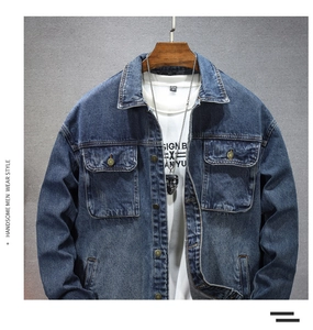 Détail de la veste en jean bleu montrant la texture délavée et les boutons métalliques