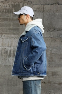 Close-up of blue denim jacket with warm white sherpa lining and classic chest pockets