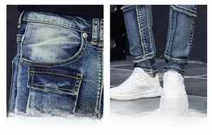 Detailed view of dark blue men's distressed slim jeans with heavy wash and pocket design