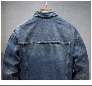Détails du dos de la veste en denim épais montrant la texture bleue et les coutures