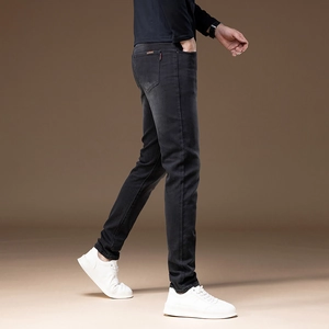 Detail view of charcoal black slim fit men's stretch denim jeans with red pocket tag