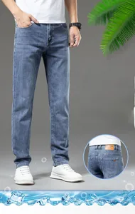 Detailed view of brown leather brand label on light blue slim fit men's denim jeans