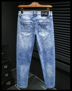 Detail of dark blue snowflake washed denim jeans with branded leather patch and embroidery