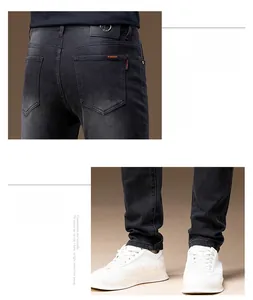 Detail view of black slim-fit denim jeans with rear pockets and Warning label accents