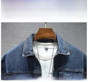 Détail du col d'une veste en jean bleue avec doublure et étiquette sur cintre en bois