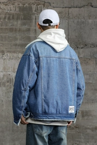 Detail view of denim jacket featuring warm lamb wool collar and streetwear brand patch