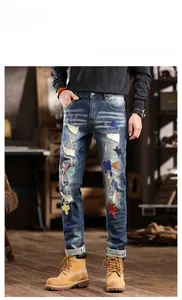 Detail of distressed denim jeans with colorful star patches and washed whiskers