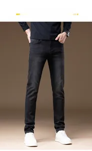 Detailed close-up showing washed black denim texture and slim fit design for men