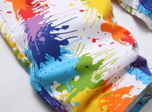 Gros plan sur l'imprimé taches de peinture multicolores sur tissu en denim blanc