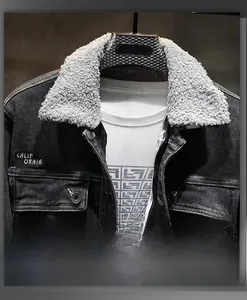 Dettaglio giacca in denim scuro con colletto in pelliccia grigia e ricamo California