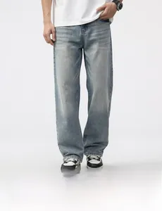 Detail of light blue washed denim jeans featuring whiskering and straight leg cut